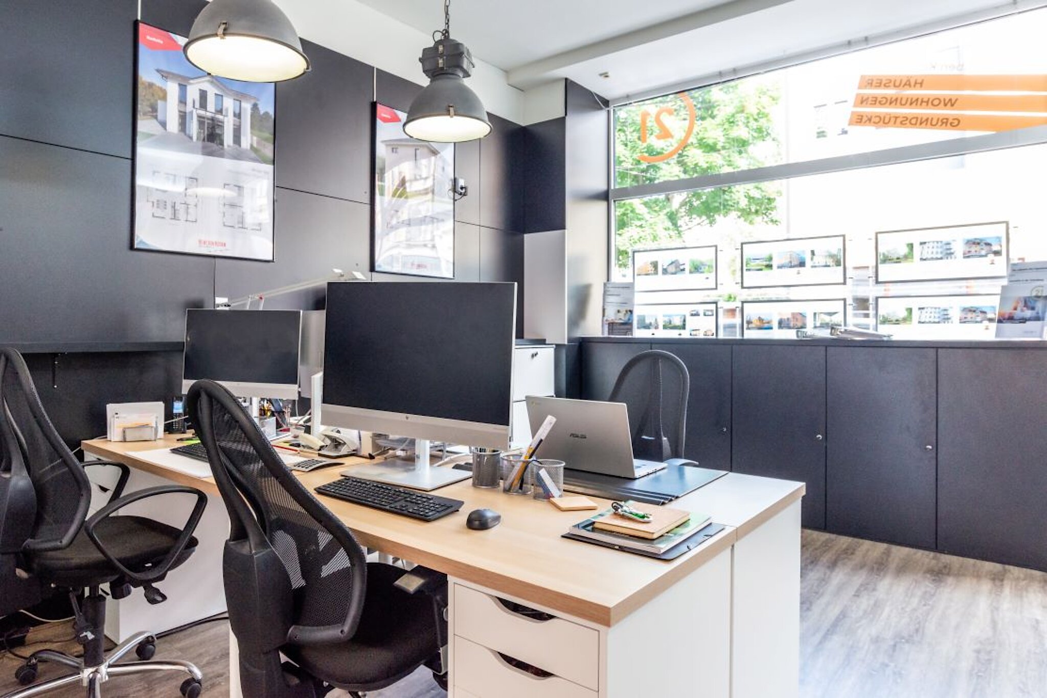Modern eingerichtetes Büro mit mehreren Arbeitsplätzen.