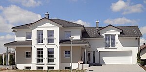 Außenansicht des modernen Stadtbüros Gunningen mit Garage und großer Auffahrt. 