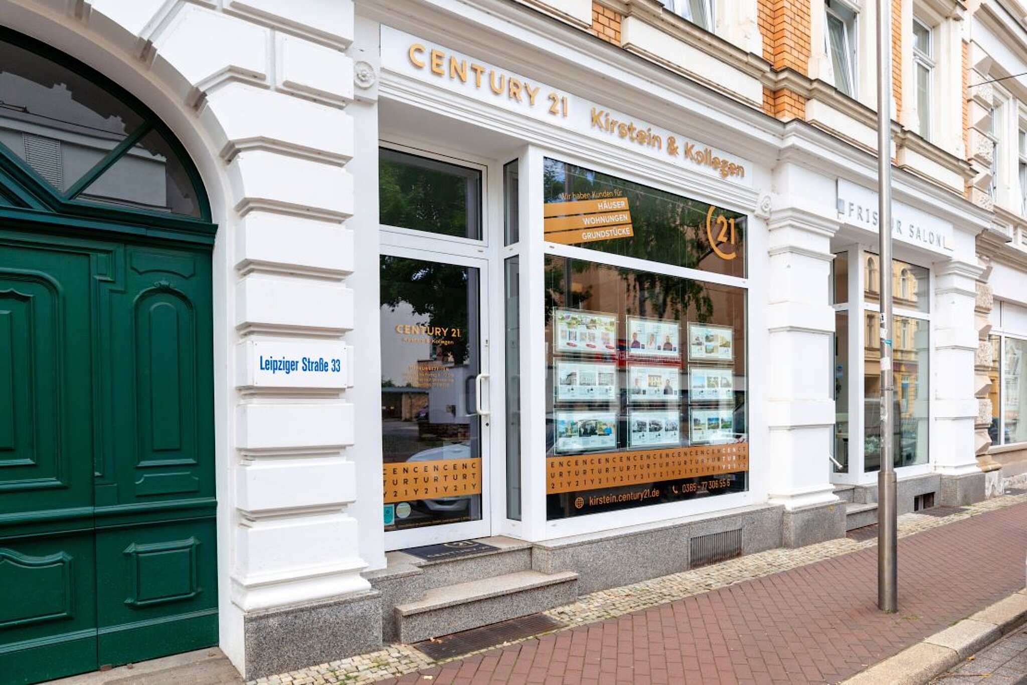 Außenansicht des Century 21 Büros mit großer Fensterfront.