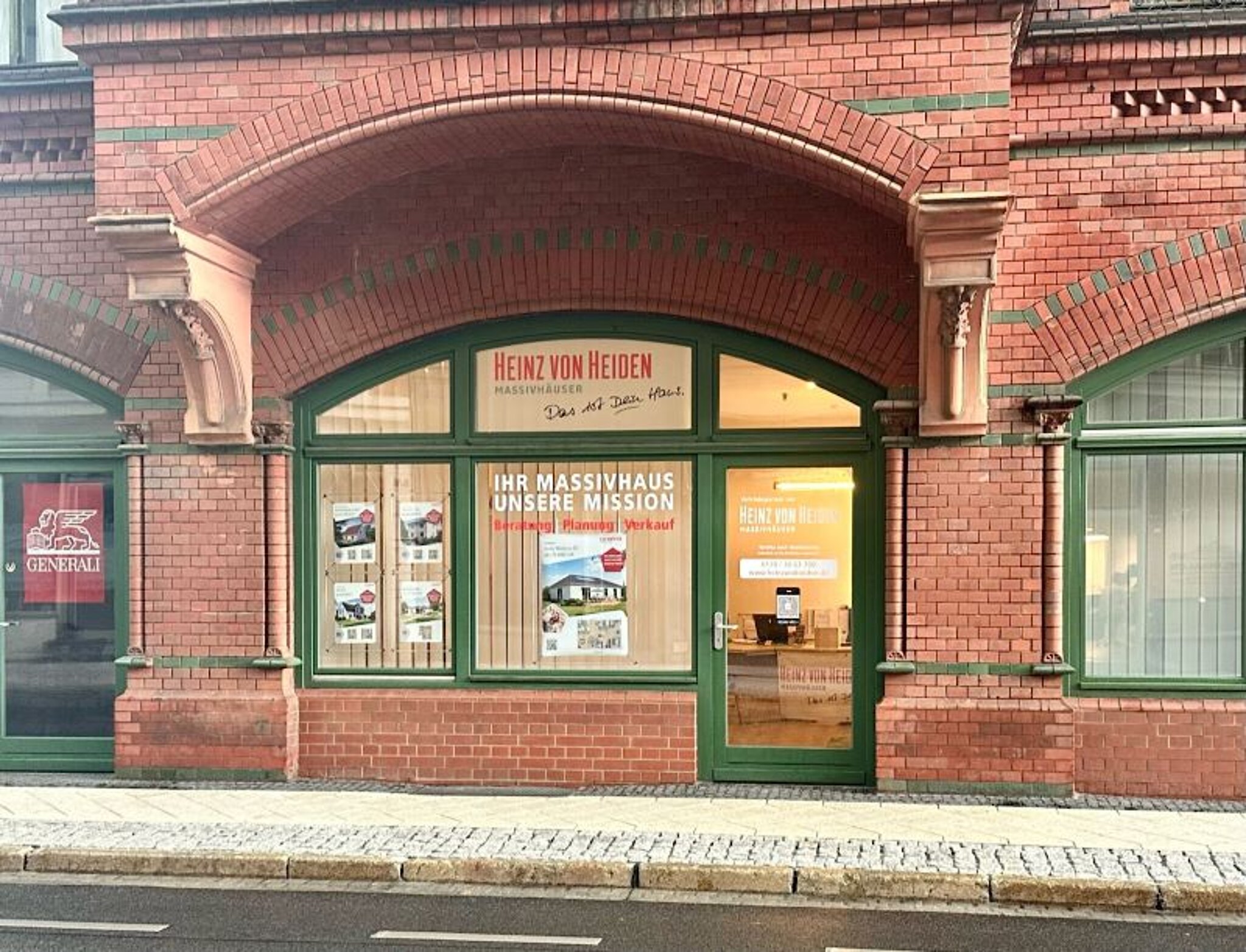 Eingangsbereich des Stadtbüros Cottbus mit grüner Fensterfront.