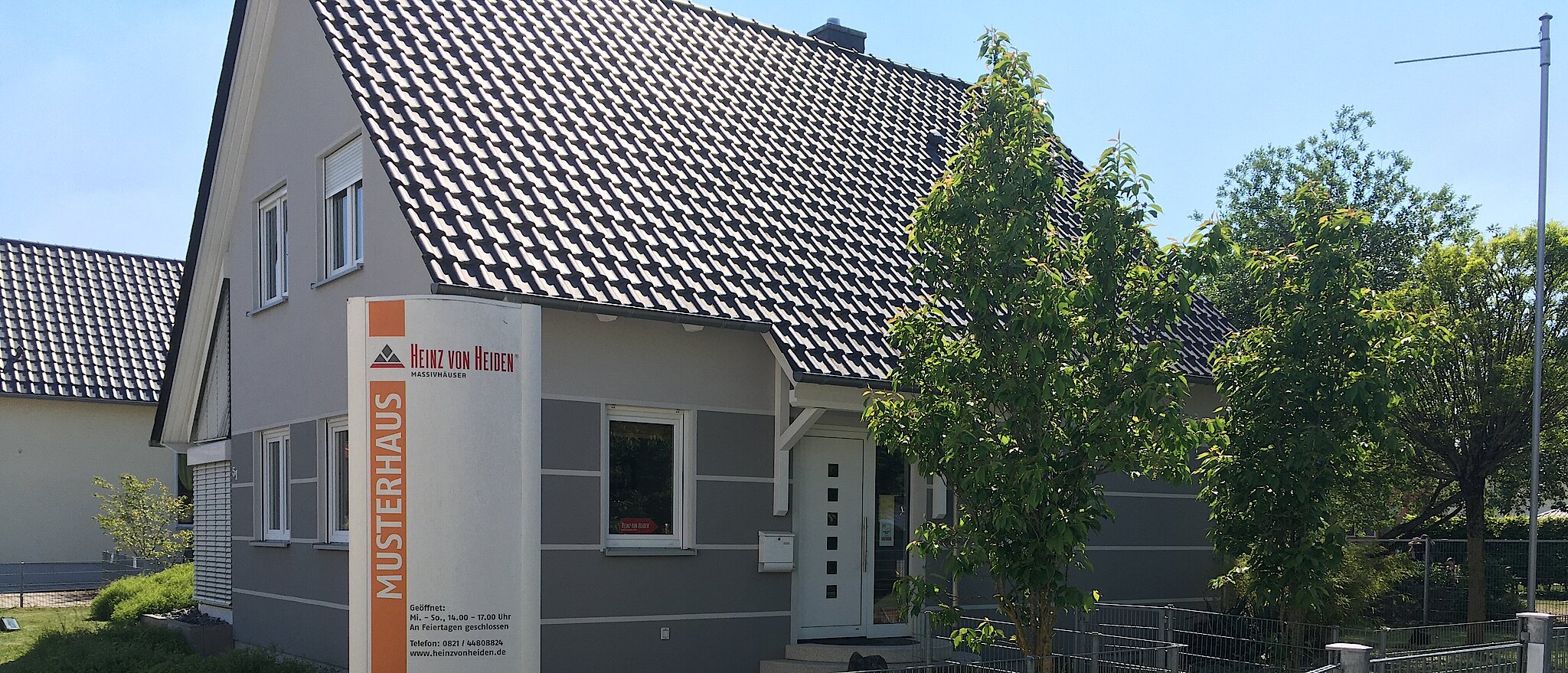 Modernes Einfamilienhaus des Musterhauses Augsburg mit Gartenansicht.
